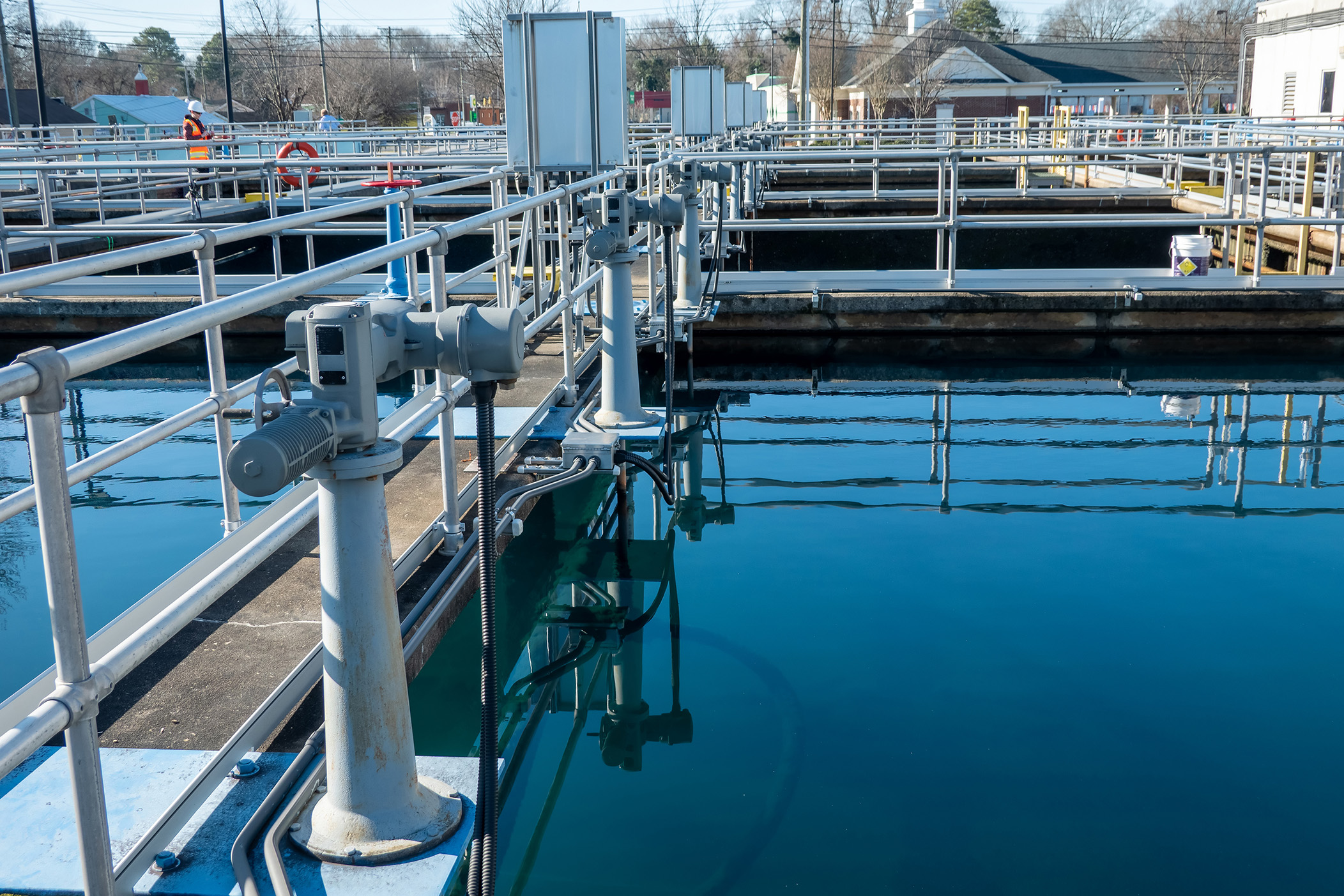 Enisca Browne - A water treatment facility with clear blue water, railings, and equipment visible around the tanks.